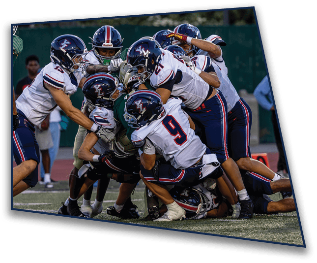 Several people wearing sports gear are on the ground in a close group on a grassy field, appearing to be involved in a physical activity or sport. Description generated by AI