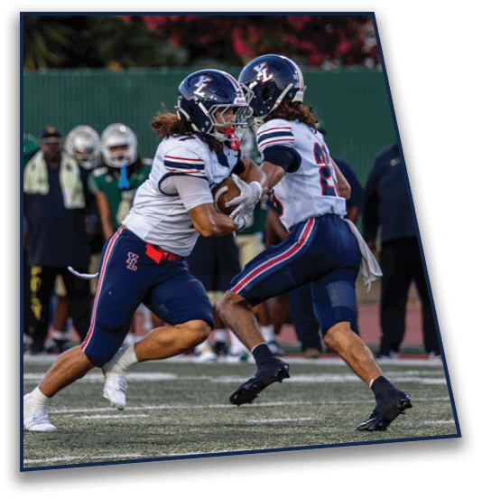 Two people in athletic uniforms are running on a sports field with others standing in the background. Description generated by AI