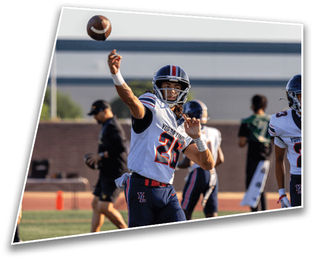 A person wearing a football helmet and uniform is throwing a football in an outdoor setting. Description generated by AI