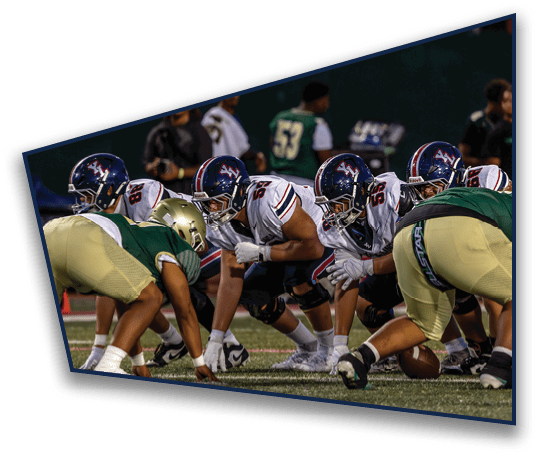 Several people wearing sports uniforms and cleats are positioned on a grassy field, appearing to prepare for a play in a football game. Description generated by AI