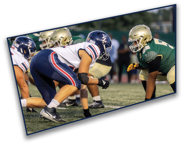 People in football uniforms are lined up on a field facing each other, preparing for a play. Description generated by AI