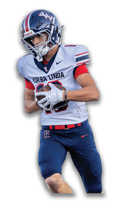 A person wearing a Yorba Linda football uniform is running while holding a football. Description generated by AI