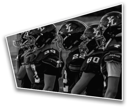 A group of people wearing football helmets and uniforms stand closely together in a line, facing the same direction. Description generated by AI