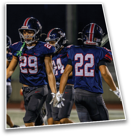 Several people wearing dark sports uniforms with numbers and gloves are walking or running on a field. Description generated by AI
