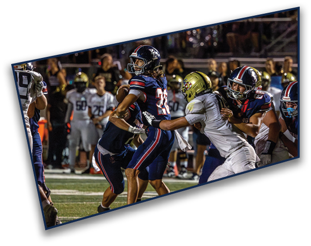 People wearing sports uniforms and cleats are engaged in a football game on a grassy field. Description generated by AI