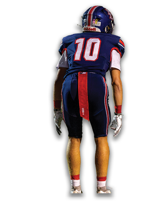 A person wearing a blue football uniform with the number 10 on the back is standing facing away. Description generated by AI