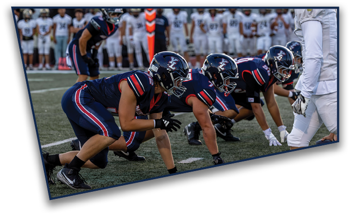 A group of people wearing sports helmets and uniforms are gathered closely together, appearing to be engaged in a team activity or game. Description generated by AI