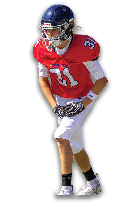 A person wearing a red football jersey with the number 31, white pants, gloves, and cleats is in a crouched position on a white background. Description generated by AI