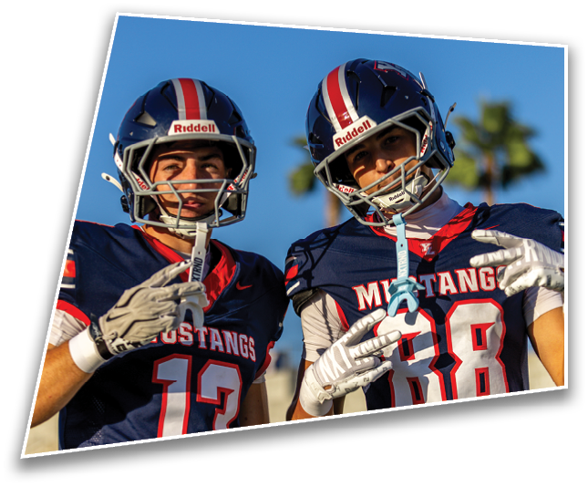 Two people wearing dark blue sports jerseys with the word “Mustangs" and numbers 13 and 88 are making hand gestures. Description generated by AI