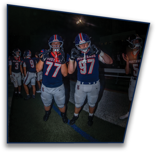 Two people wearing blue helmets with red and white stripes are looking up at bright stadium lights against a dark night sky. Description generated by AI