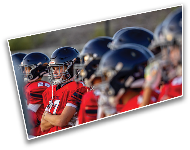People wearing red sports jerseys are standing closely together, with one person crossing their arms. Description generated by AI
