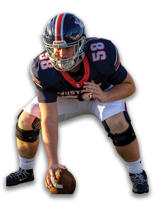 A person wearing a football uniform with a helmet and knee brace is crouched in a ready position on the field. Description generated by AI