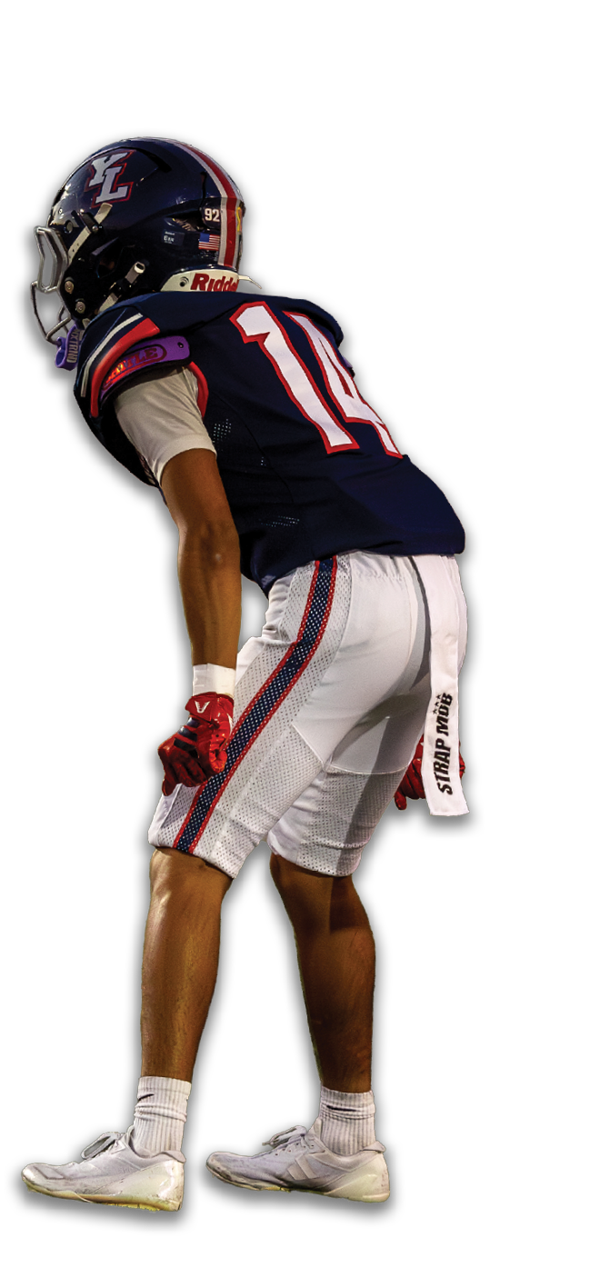 A person wearing a dark football uniform with the number 11 on the back is bent forward in a ready stance. Description generated by AI