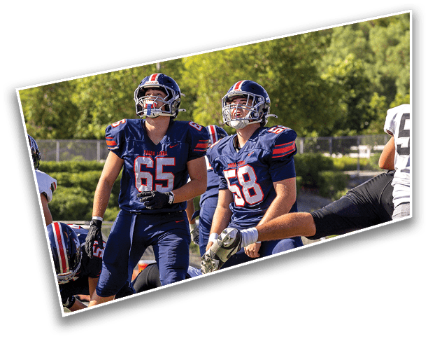 People wearing red sports jerseys are standing closely together, with one person crossing their arms. Description generated by AI
