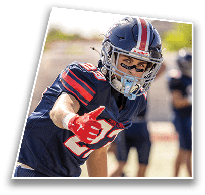 A person wearing a blue and red football helmet and uniform with eye black under their eyes is looking intently to the side. Description generated by AI