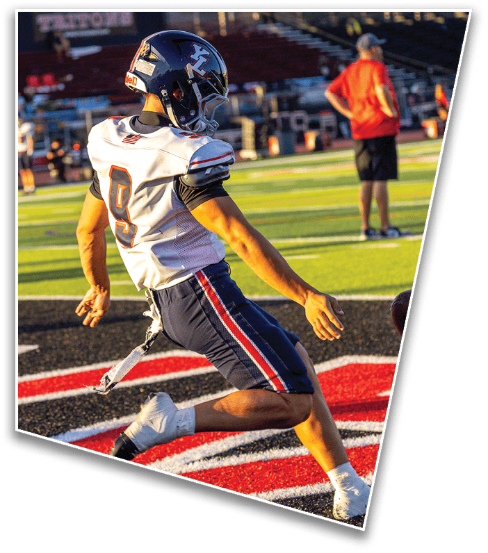 A person wearing a football uniform with the number 9 is kicking a football on a field near the end zone. Description generated by AI