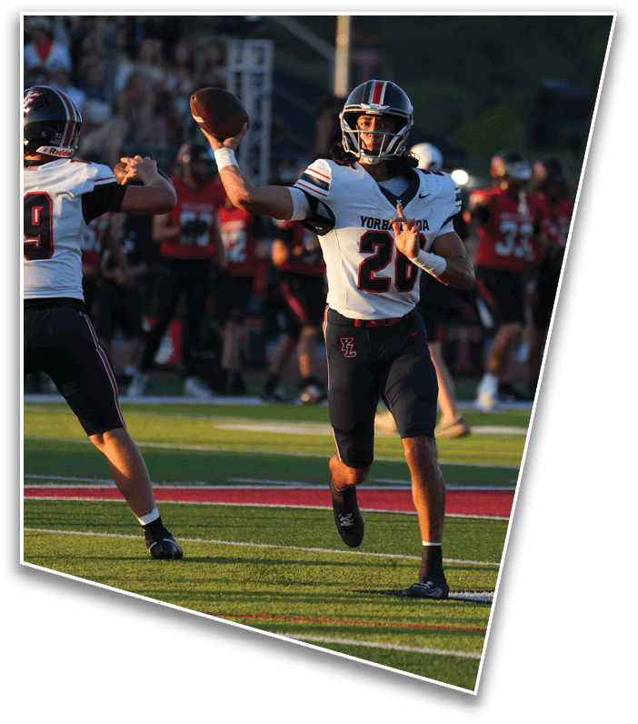A person wearing a football helmet and jersey is preparing to throw a football during a game. Description generated by AI