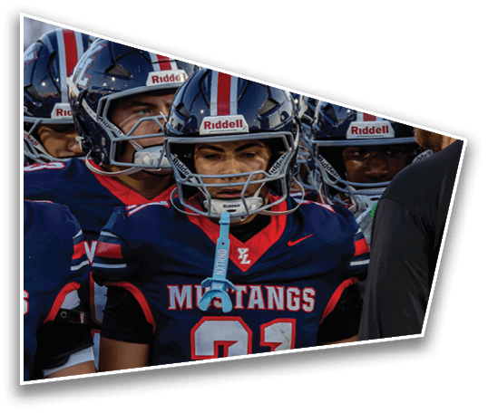 People wearing navy blue football uniforms with red and white accents stand closely together, with one uniform prominently displaying the number 21 and the word Mustangs. Description generated by AI