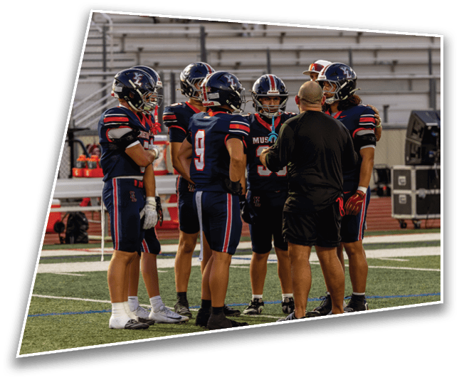 A group of people wearing athletic shorts and cleats are standing in a circle on a sports field. Description generated by AI