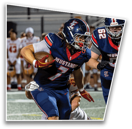 A person wearing a blue football uniform with “Mustangs" on the chest and a helmet is running while holding a football during a game. Description generated by AI