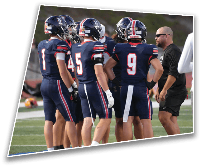 A group of people wearing football uniforms are gathered on a field while a person in casual athletic clothing appears to be giving instructions. Description generated by AI