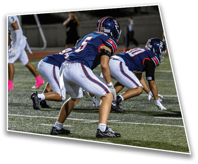 People wearing athletic shoes and sports socks are positioned on a turf field, appearing ready to start a race or sprint. Description generated by AI