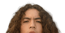 A person with long curly hair wearing a navy blue football jersey with the word Mustangs and the number seven stands against a plain gray background. Description generated by AI