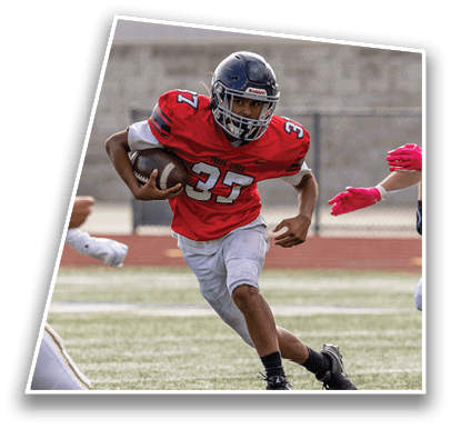 A person wearing a red football jersey with the number 37 is running with a football while another person in a white uniform and yellow helmet reaches out toward them on a sports field. Description generated by AI