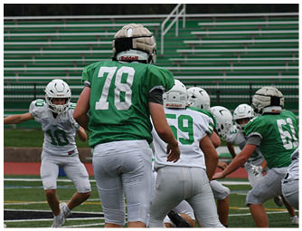 A group of football players on a field. Description generated by AI