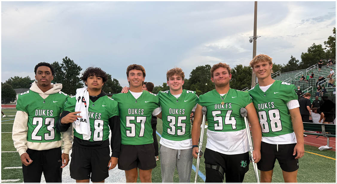 A group of football players on a field. Description generated by AI