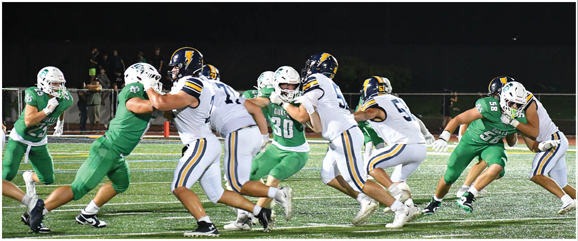 A group of football players on a field. Description generated by AI