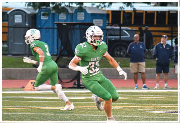 Two football players celebrating on the field. Description generated by AI