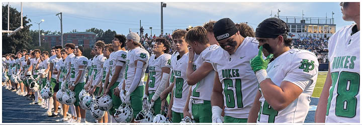 A group of football players on a field. Description generated by AI
