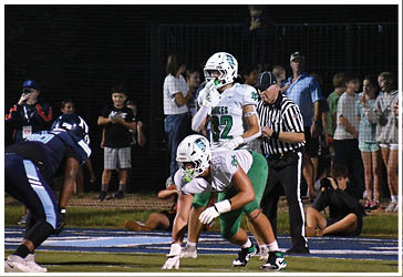 Two football players celebrating on the field. Description generated by AI