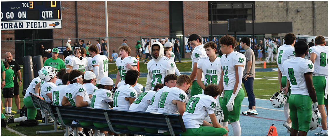 A group of football players on a field. Description generated by AI