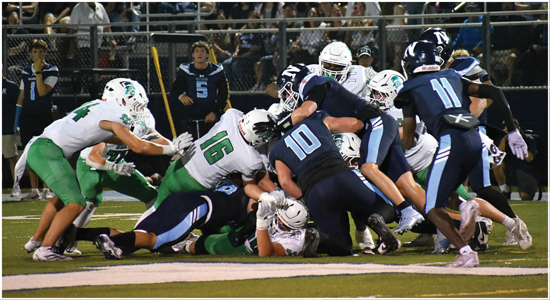 A group of football players on a field. Description generated by AI