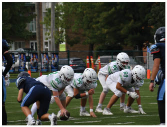 A group of football players on a field. Description generated by AI