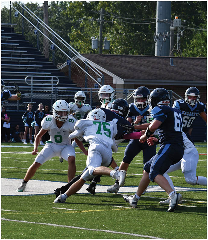 Three football players in blue and white uniforms running on a field. Description generated by AI
