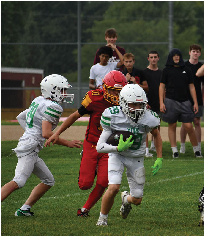 Three football players in blue and white uniforms running on a field. Description generated by AI