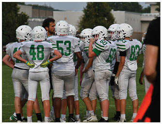 A group of football players on a field. Description generated by AI