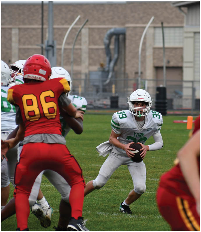 Three football players in blue and white uniforms running on a field. Description generated by AI