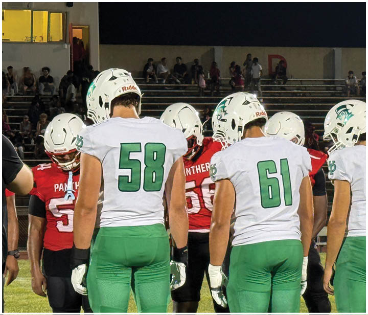 A group of football players on a field. Description generated by AI