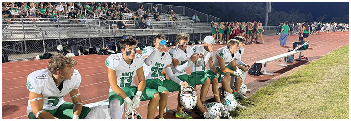 A group of football players on a field. Description generated by AI