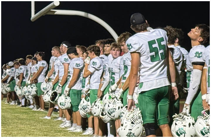 A group of football players on a field. Description generated by AI