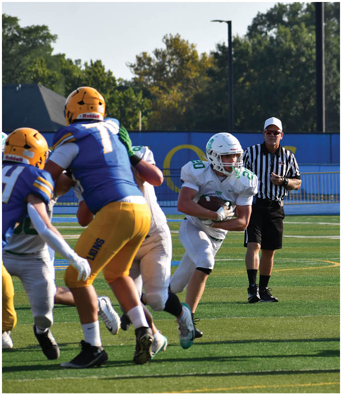 Three football players in blue and white uniforms running on a field. Description generated by AI