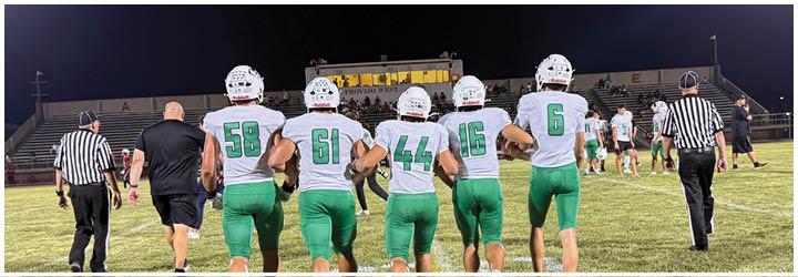 A group of football players on a field. Description generated by AI