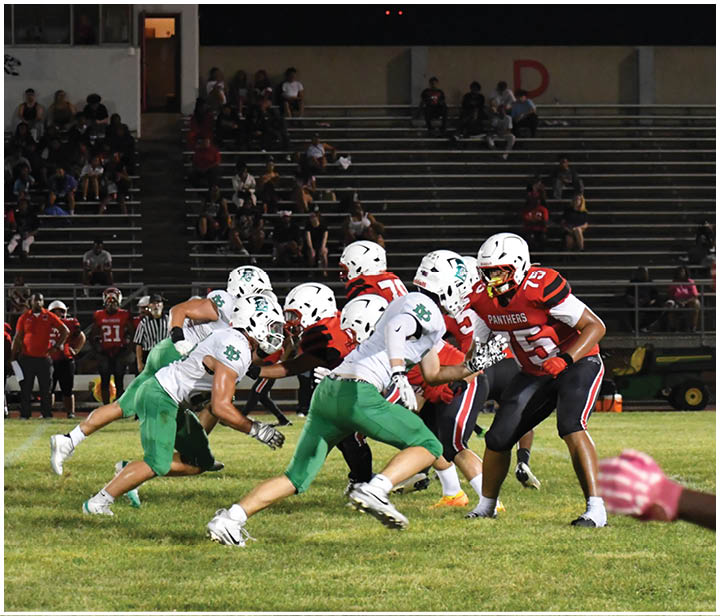 A group of football players on a field. Description generated by AI