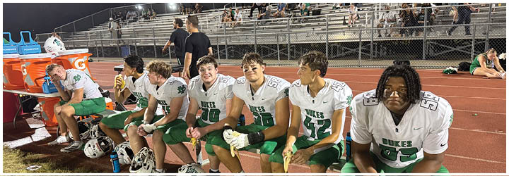 A group of football players on a field. Description generated by AI