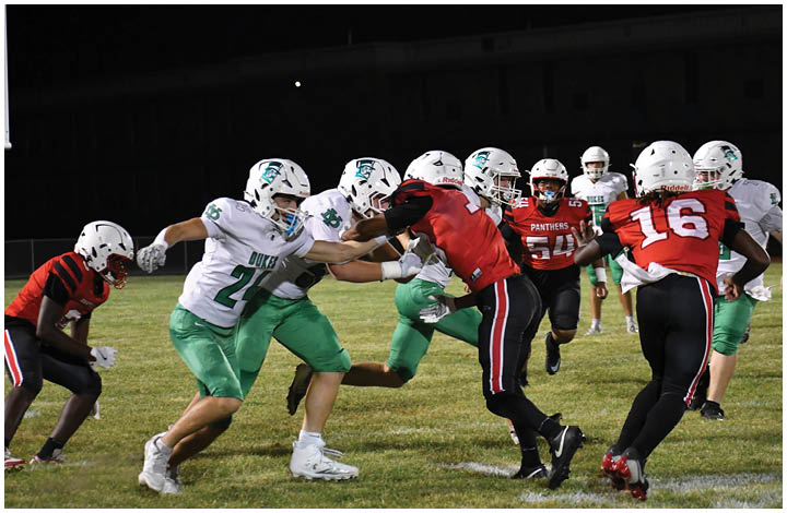 A group of football players on a field. Description generated by AI