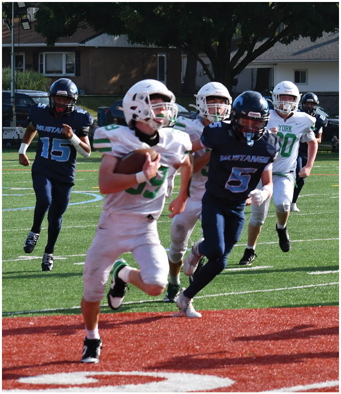 Three football players in blue and white uniforms running on a field. Description generated by AI